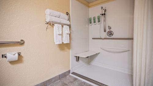 a bathroom with a shower and a toilet and towels at Best Western Center Pointe Inn in Branson