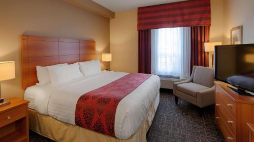 um quarto de hotel com uma cama e uma televisão de ecrã plano em Best Western Thompson em Thompson