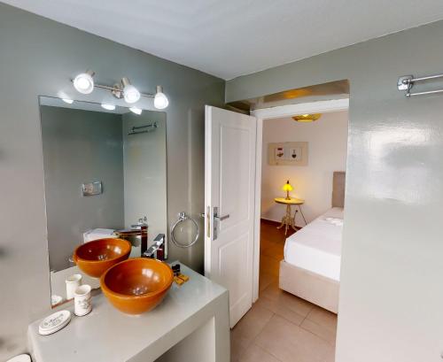 a bathroom with two orange sinks on a counter at NEOKLASSIKO KOUKOULI in Fira