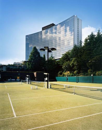 two tennis courts with a building in the background at Grand Hyatt Seoul in Seoul