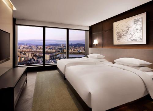a bedroom with two beds and a large window at Grand Hyatt Seoul in Seoul