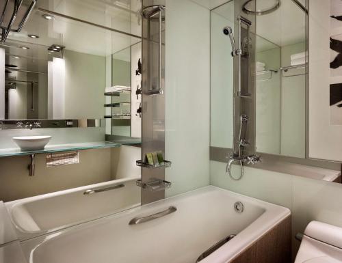 a bathroom with a tub and a sink and a mirror at Grand Hyatt Seoul in Seoul