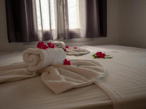 two towels on a bed with flowers on it at NEOKLASSIKO KOUKOULI in Fira