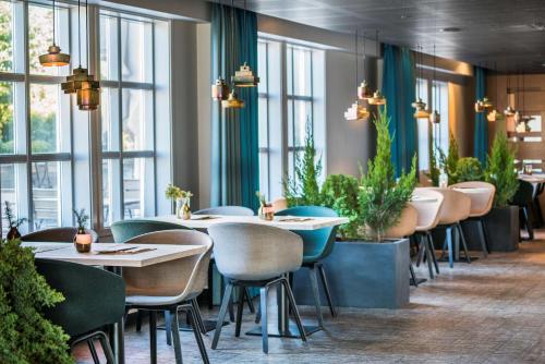 a restaurant with tables and chairs and windows at Radisson Blu Royal Hotel, Bergen in Bergen