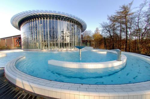 a large swimming pool in front of a building at Van der Valk Hotel Spa in Spa