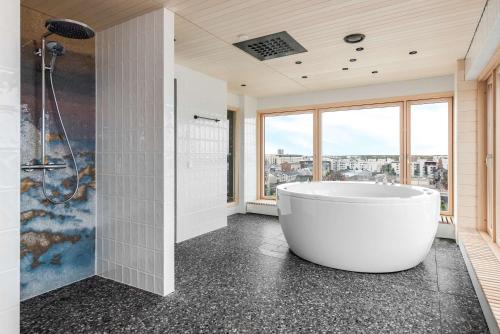 a bathroom with a tub and a bathtub in it at Radisson Blu Hotel, Oulu in Oulu