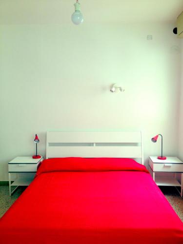 a bedroom with a red bed with two night stands at Casa Julia in Cividale del Friuli