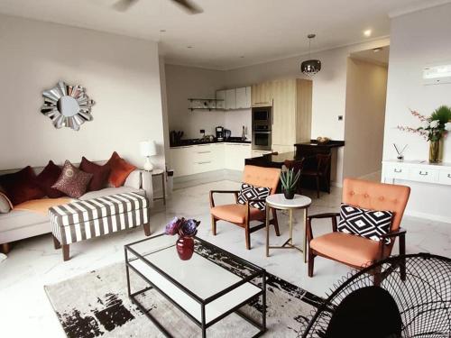 a living room with a couch and a table at One Rodney Heights Condominiums in Gros Islet