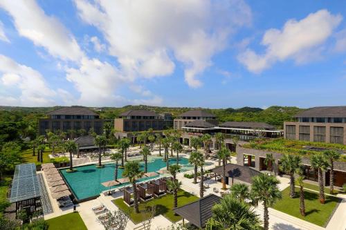 烏魯瓦圖的住宿－巴厘烏魯瓦圖麗笙酒店，享有度假村的空中景致,设有游泳池和棕榈树