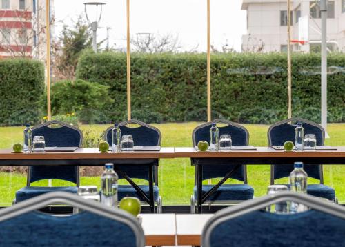 a long wooden table with chairs and a table with glasses at Radisson Blu Hotel Istanbul Asia in Istanbul