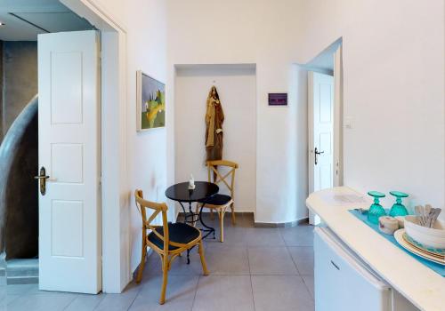 a kitchen with a table and chairs and a door at NEOKLASSIKO KOUKOULI in Fira