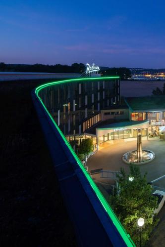 a building with green lights on the side of it at Radisson Hotel Zurich Airport in Rümlang