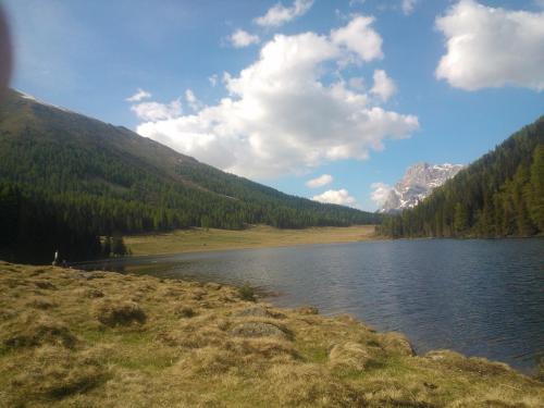 a lake in the middle of a mountain with trees at Hotel Serenella in Canale San Bovo