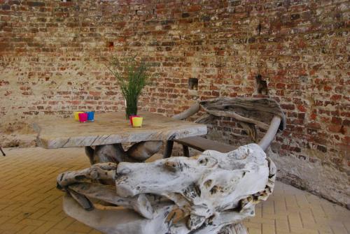 a wooden table with two cups and a plant on it at Bed and Breakfast de Meule Montfort in Montfort