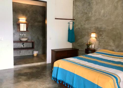 a bedroom with a bed and a wall at Casa Monika in Puerto Escondido