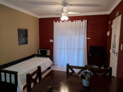 a bedroom with a bed and a table and a ceiling fan at Guardalaola Patagonia Puelche in Las Grutas
