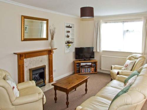 uma sala de estar com dois sofás e uma lareira em Matlock Green em Matlock