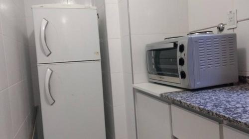 eine Küche mit einem weißen Kühlschrank und einer Mikrowelle in der Unterkunft Departamentos Mendoza in Mendoza