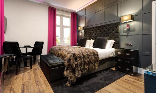 a bedroom with a large bed and a chair at Kotel Windermere in Windermere