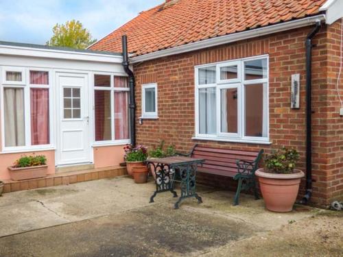 a bench sitting outside of a house with windows at Glenhaven in Rendham