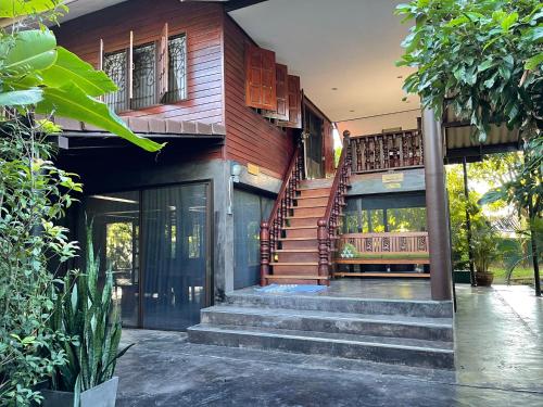 a house with a staircase in the front of it at HomeandHomestay Chiang Kham in Chiang Kham