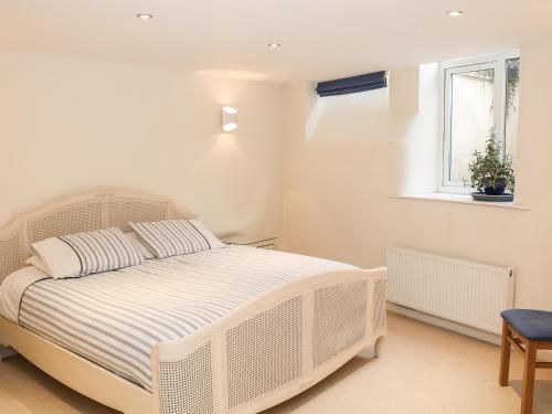 - un lit blanc dans une chambre blanche dotée d'une fenêtre dans l'établissement 32A, Buxton, à Buxton