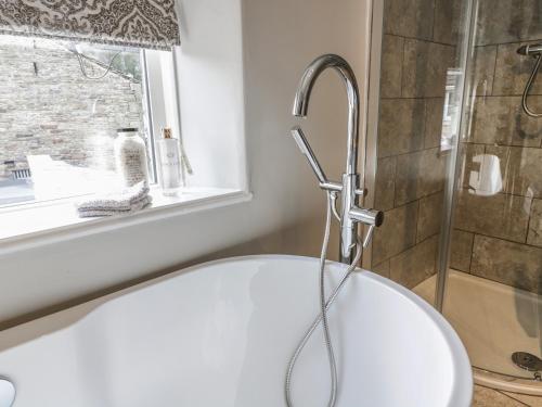 a bath tub in a bathroom with a shower at The Snug in Keighley