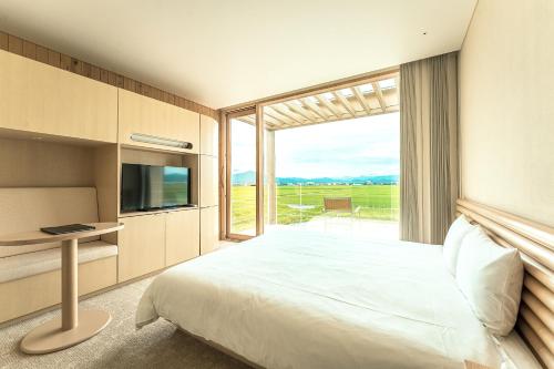 a bedroom with a bed and a large window at Shonai Hotel Suiden Terrasse in Tsuruoka