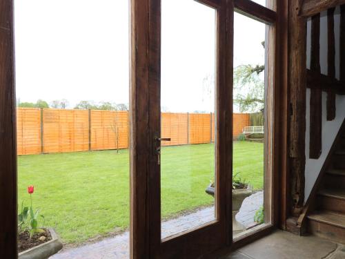 an open window with a view of a yard at Harbourne Oast in Tenterden