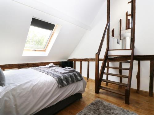 a bedroom with a bed and a stair case at Harbourne Oast in Tenterden