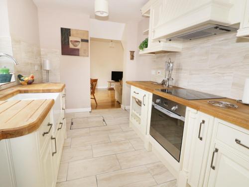 a kitchen with white cabinets and a stove top oven at The Lodge in Brandon