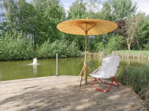 a chair and an umbrella sitting on a wooden dock at The Lodge in Brandon