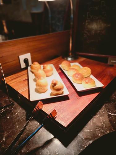 two plates of donuts sitting on a wooden table at Swiss-Belhotel Cendrawasih, Biak in Fandoi