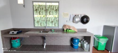 encimera de cocina con fregadero y ventana en D' Limbai Cottage, en Ranau