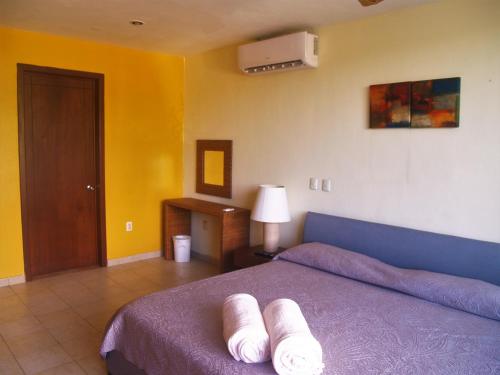 um quarto com uma cama com duas toalhas brancas em Beachfront Apartment Your Home in Cozumel em Cozumel