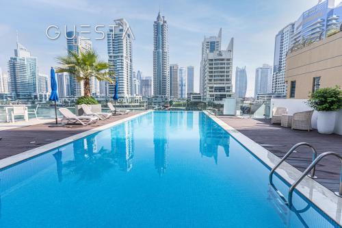a swimming pool with a city skyline in the background at LIV Residence, Dubai Marina in Dubai