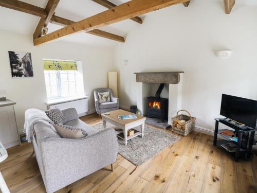 a living room with a couch and a fireplace at The Hayloft in Hawes
