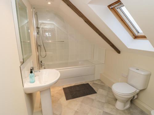 a bathroom with a toilet and a sink and a shower at The Bothy, 21 West Street in Malton