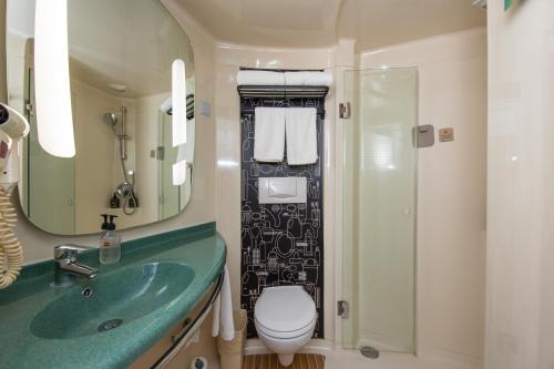 baño con lavabo verde y aseo en ibis Shanghai New Internation Expo Center Lianyang Hotel, en Shanghái