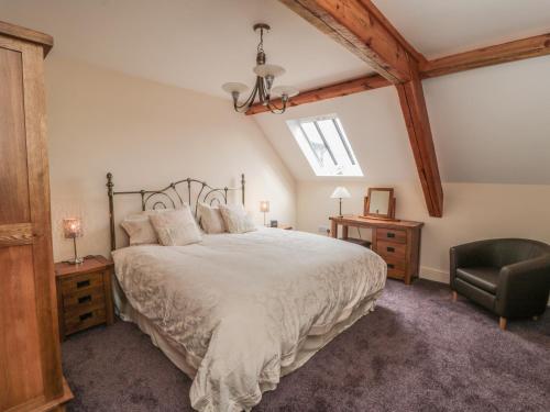 sypialnia z dużym łóżkiem i krzesłem w obiekcie New Stable Cottage w mieście Danby