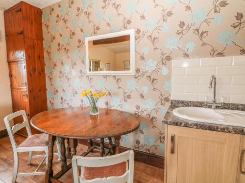 y baño con mesa, lavabo y espejo. en The Cottage at Moseley House Farm en Chinley