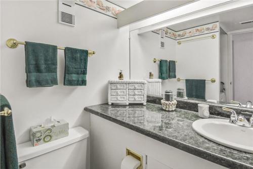 ein weißes Badezimmer mit einem Waschbecken und einem Spiegel in der Unterkunft Pyramid in Ocean City