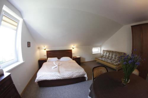 a bedroom with a bed and a couch and a table at Elena in Palanga