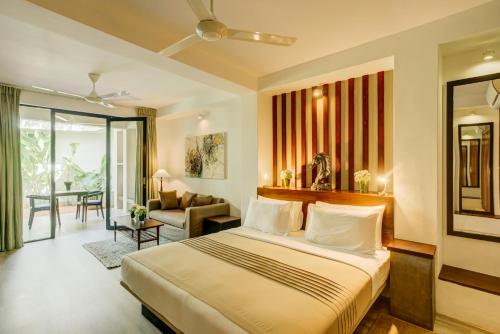 Nyne Hotels - Lake Lodge, Colombo في كولومبو: غرفة نوم مع سرير وغرفة معيشة
