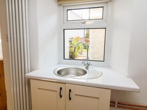 a bathroom with a sink and a window at Copper Cottage in Ingleton
