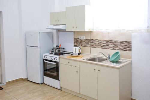 a small kitchen with a sink and a refrigerator at HAROULENA in Kavala