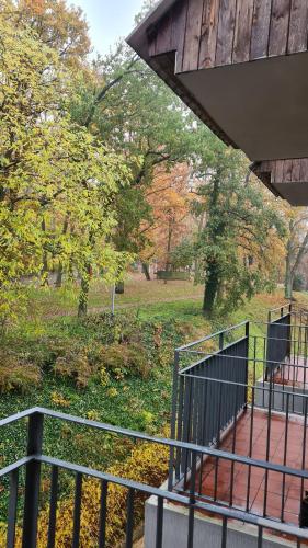 a metal railing next to a park with trees at Hotel Olimpik Park in Słubice