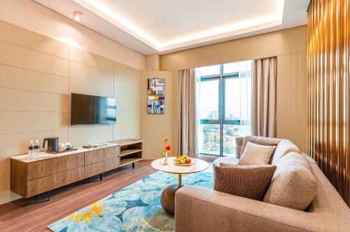 a living room with a couch and a tv and a table at M World Hotel in Petaling Jaya