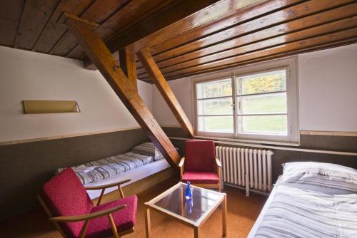 una camera con due letti e due sedie e un tavolo di Aparthotel Panorama a Deštné v Orlických horách