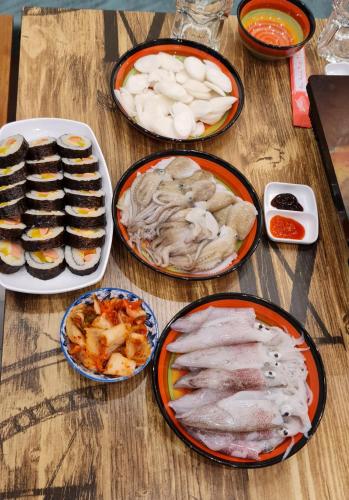 a wooden table with plates of food on it at BREAKING DAWN- TAEYANG Hotel Phú Quốc in Phu Quoc